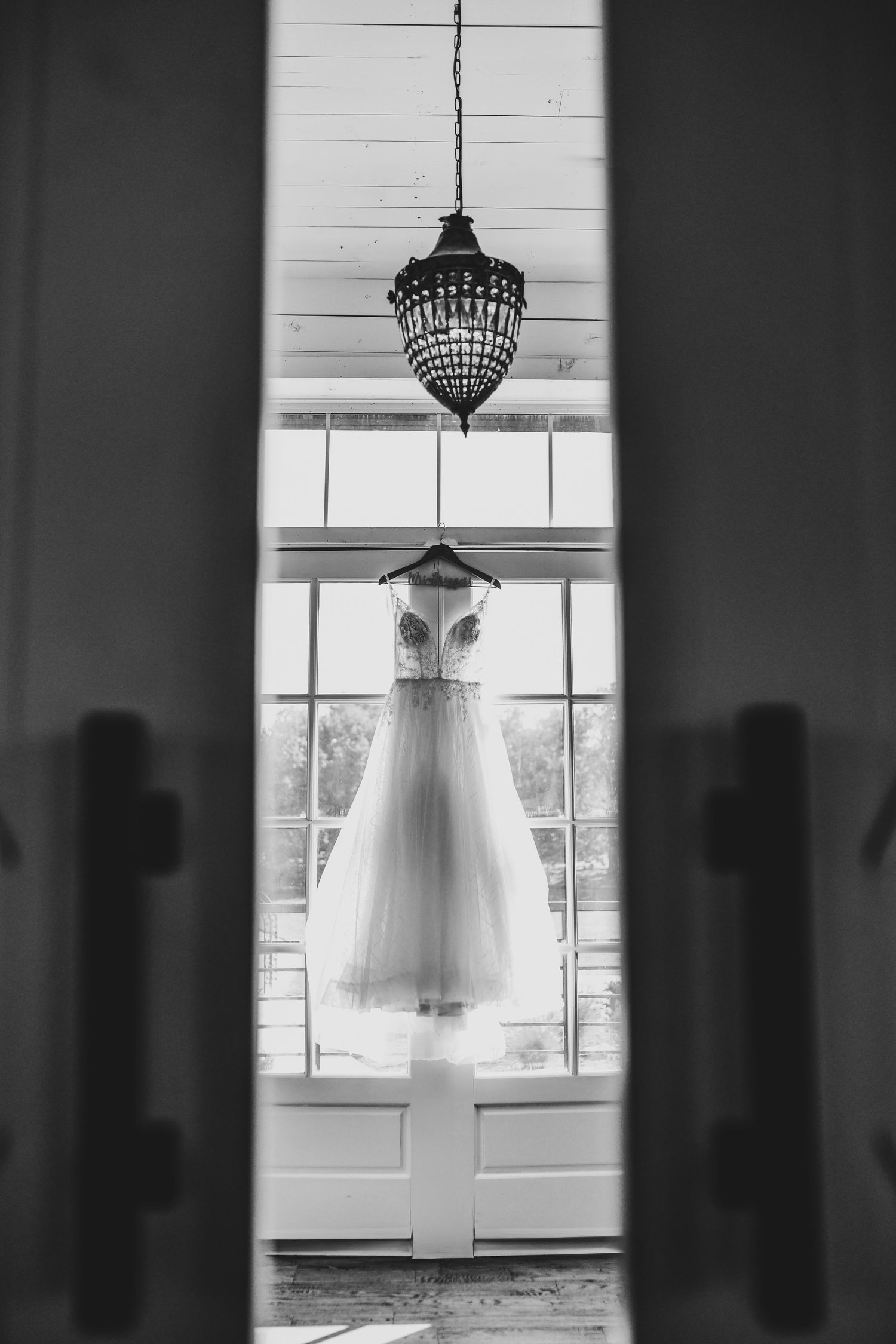 wedding dress hanging in the window at the barn at paradise