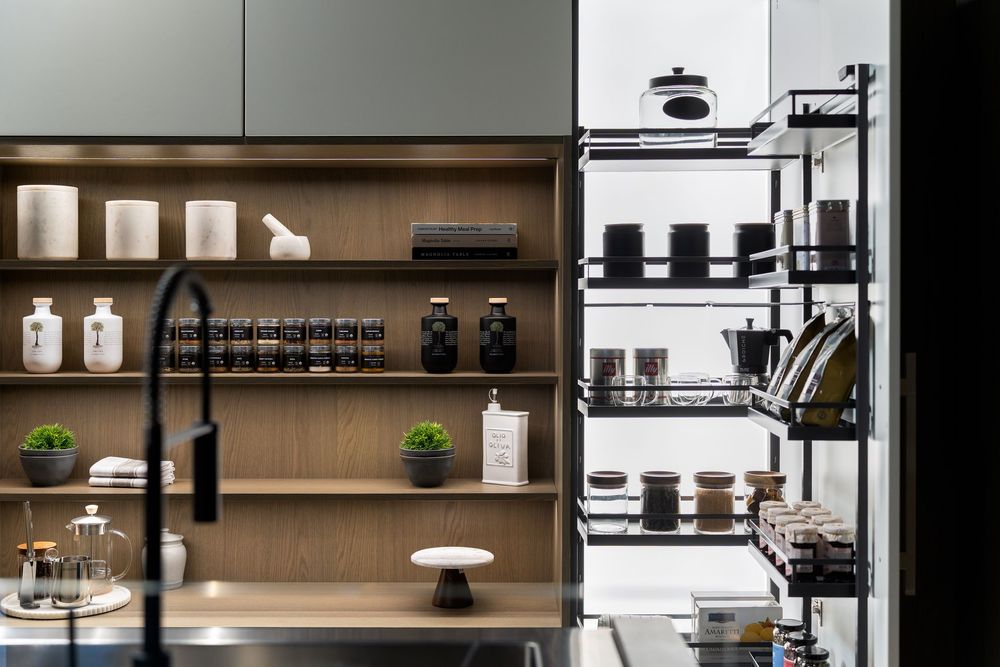 Modern kitchen shelving with black matte faucet, wooden open shelves, and organized black and white kitchenware display.