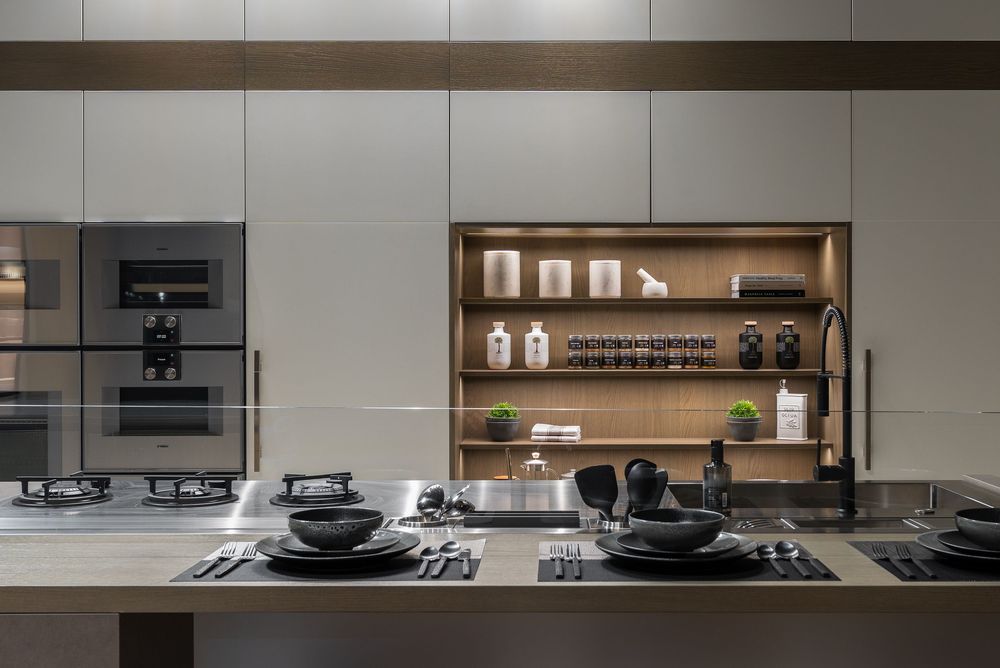 Modern minimalist kitchen with dark cabinets, wooden accents, and sleek appliances in a contemporary open layout.