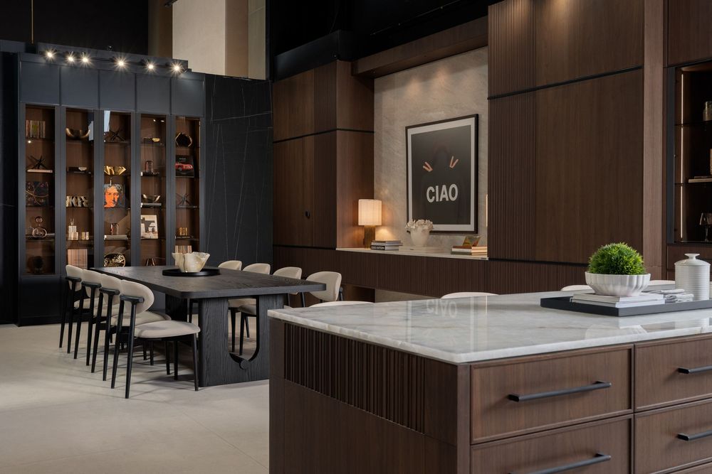 Modern luxury kitchen interior with dark wood cabinets, marble countertops, and contemporary lighting fixtures.
