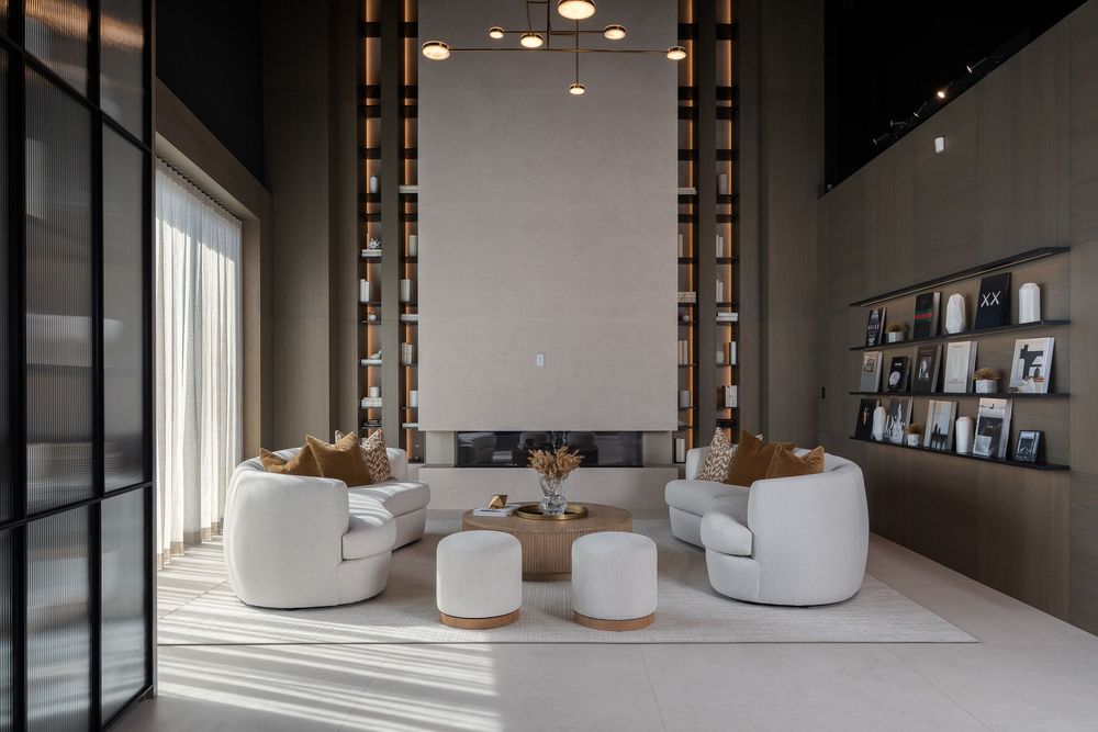 Modern office interior with curved white walls, pendant lighting, and glass partitions creating an elegant workspace design.