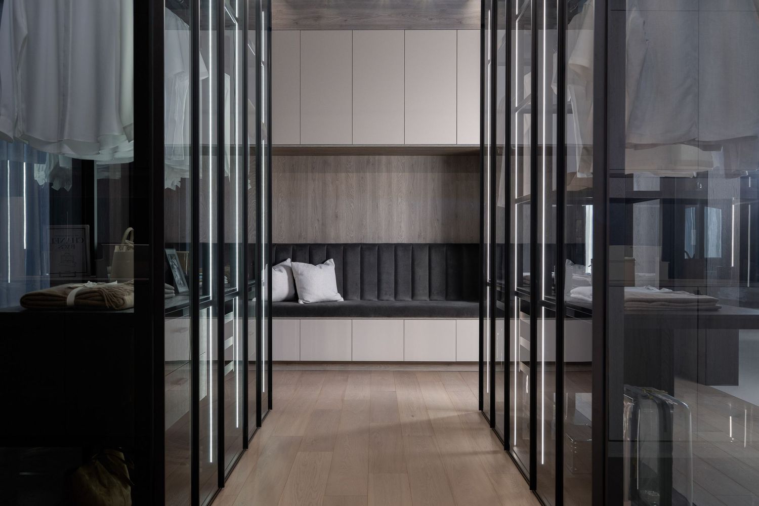 Modern office hallway with sleek glass walls and dark flooring showcases minimalist corporate interior design.