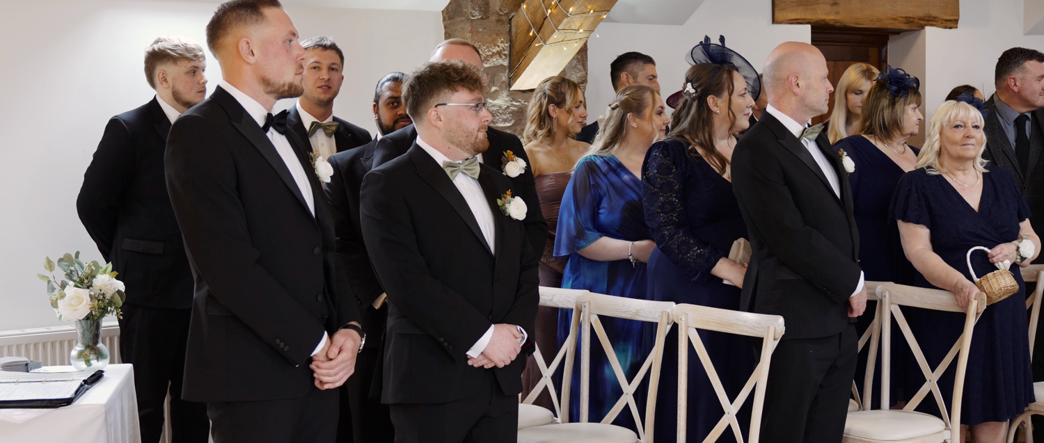 Wedding guests mingling during reception in elegant indoor venue with rustic details.