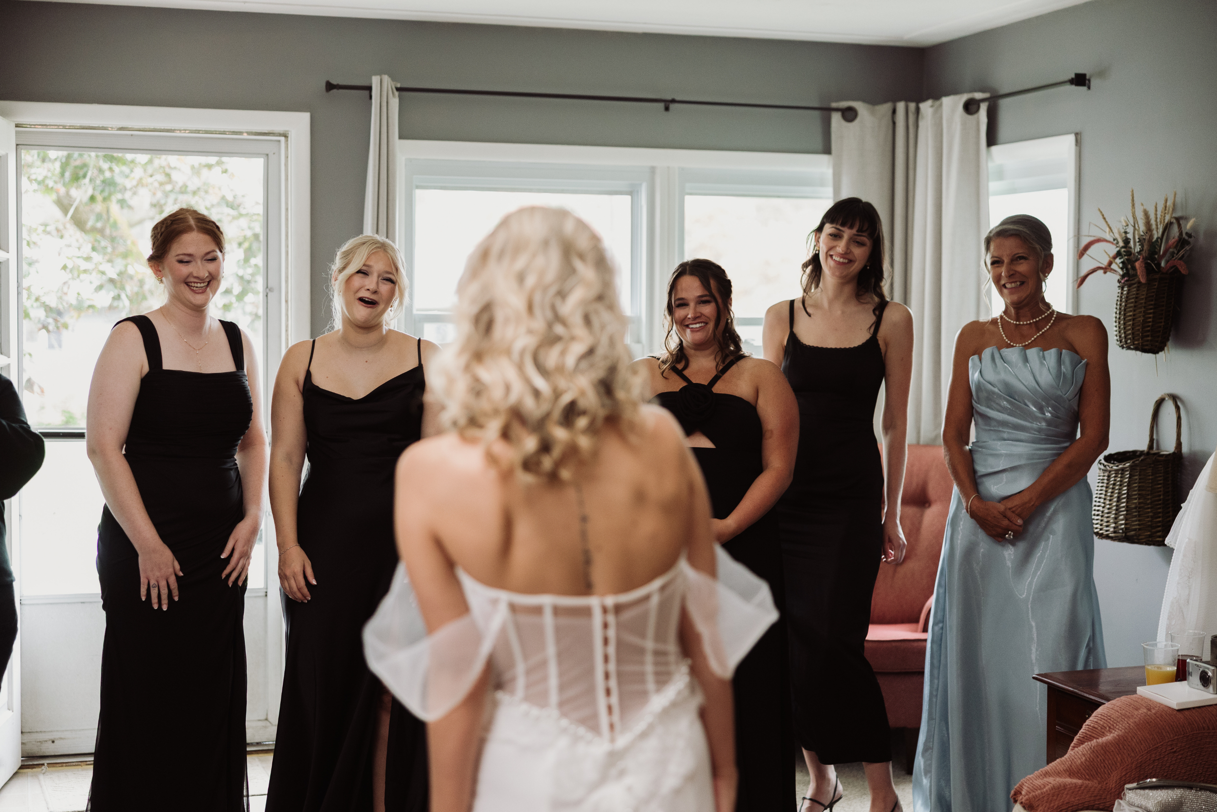 Bride having first look with bridal party and moms.