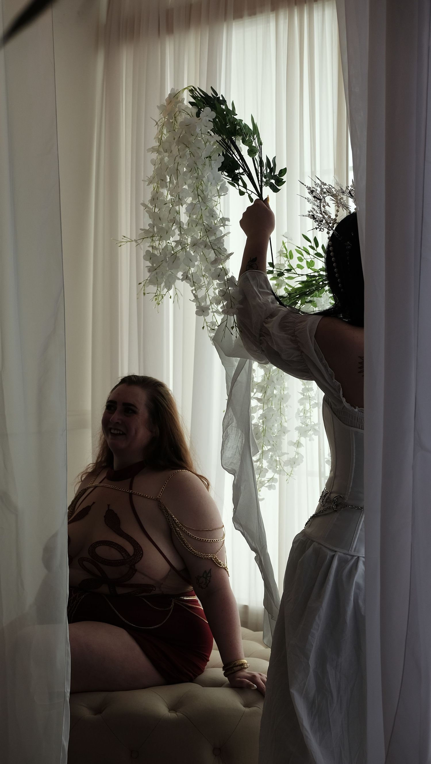 A sequence of silhouettes against sheer white curtains shows a figure dancing and moving expressively in natural light.