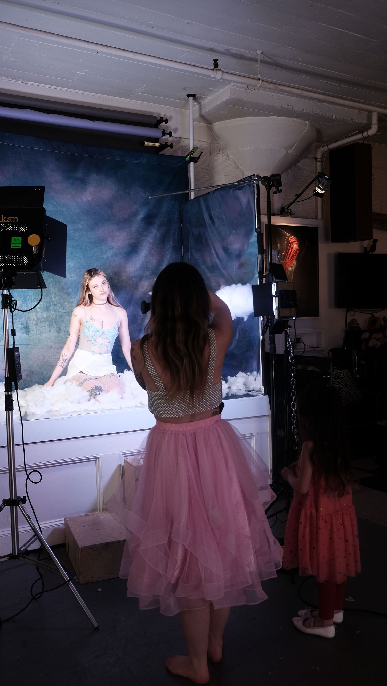 A series of studio photos showing models in pink tulle dresses posing against a moody dark backdrop.