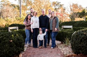 Extended family group portrait in garden path with fall foliage.