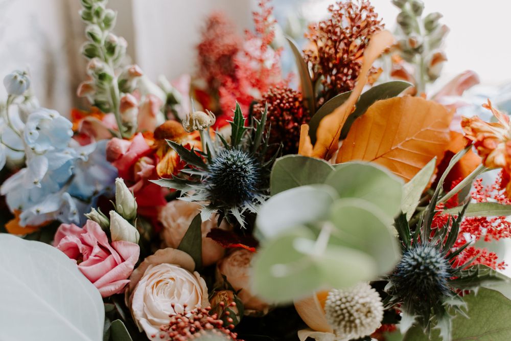 Close up of flowers in a bride’s bouquet. Thistle, eucalyptus and roses.