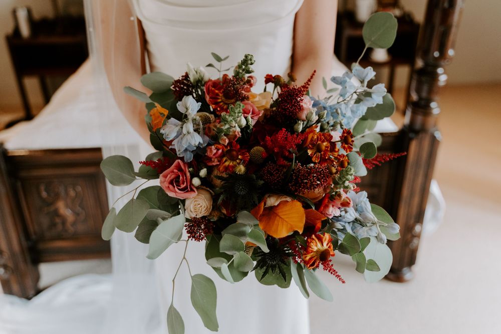 Close up of flowers in a bride’s bouquet. Thistle, eucalyptus and roses.