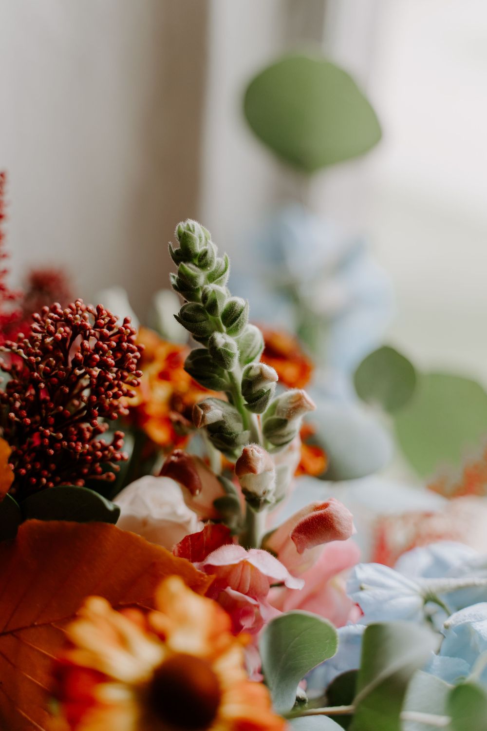 Close up of flowers in a bride’s bouquet. Thistle, eucalyptus and roses.