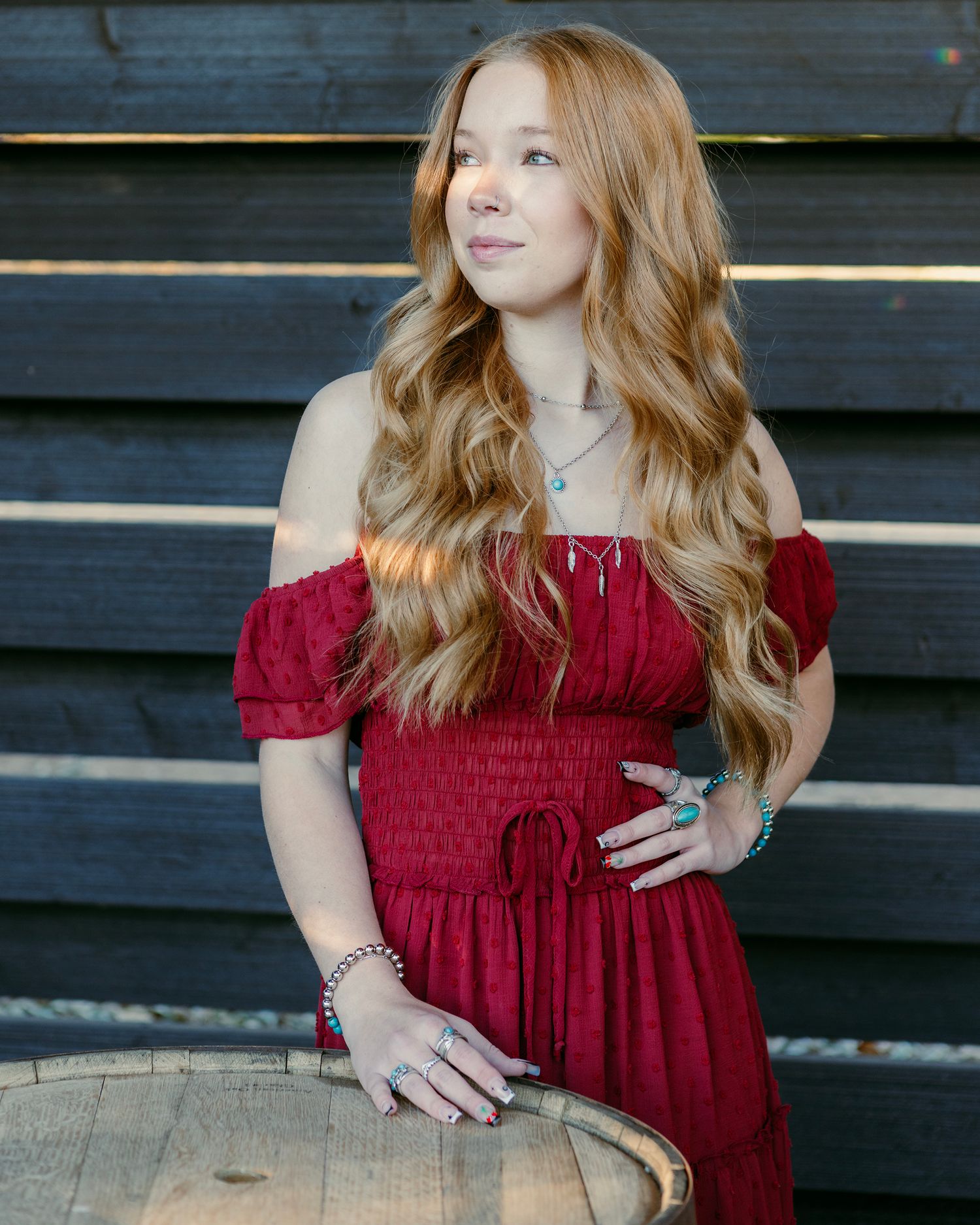 Portrait series showing different poses in a red off-shoulder dress against dark wood paneling.