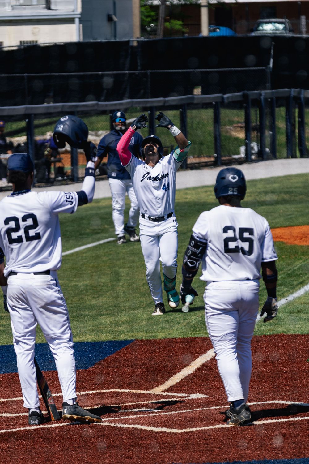Baseball player in white uniform swings bat at home plate during game sequence shown in multiple action frames.