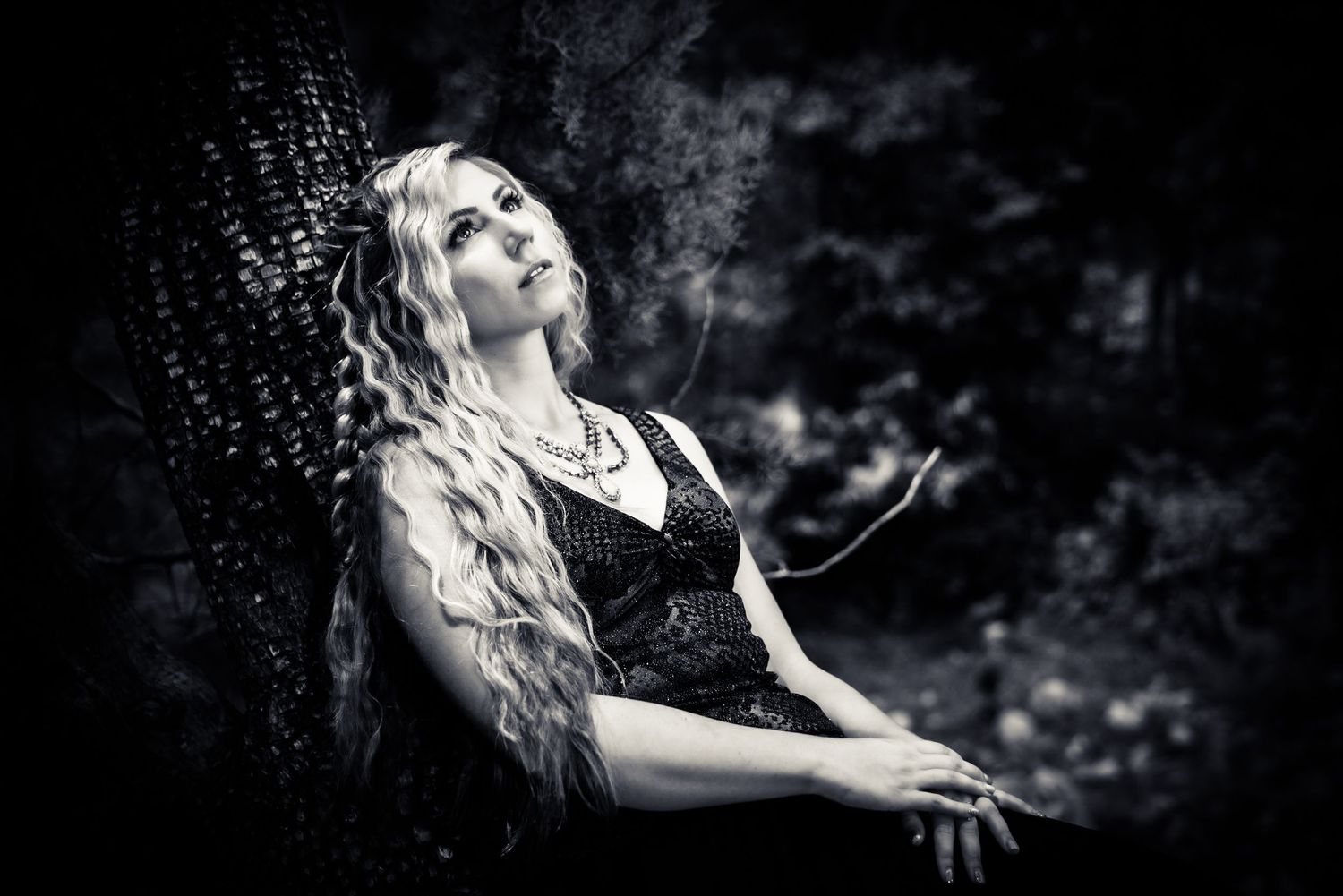 Dramatic black and white portrait with smoke effects in a moody outdoor setting.