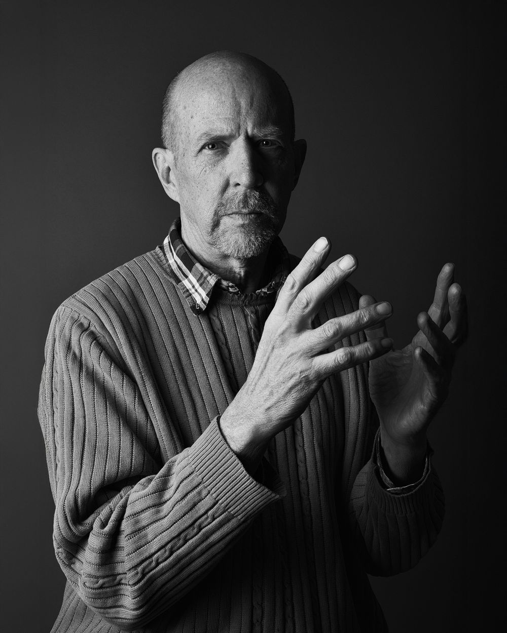 A sequence of black and white portraits showing expressive hand gestures against a dark background.