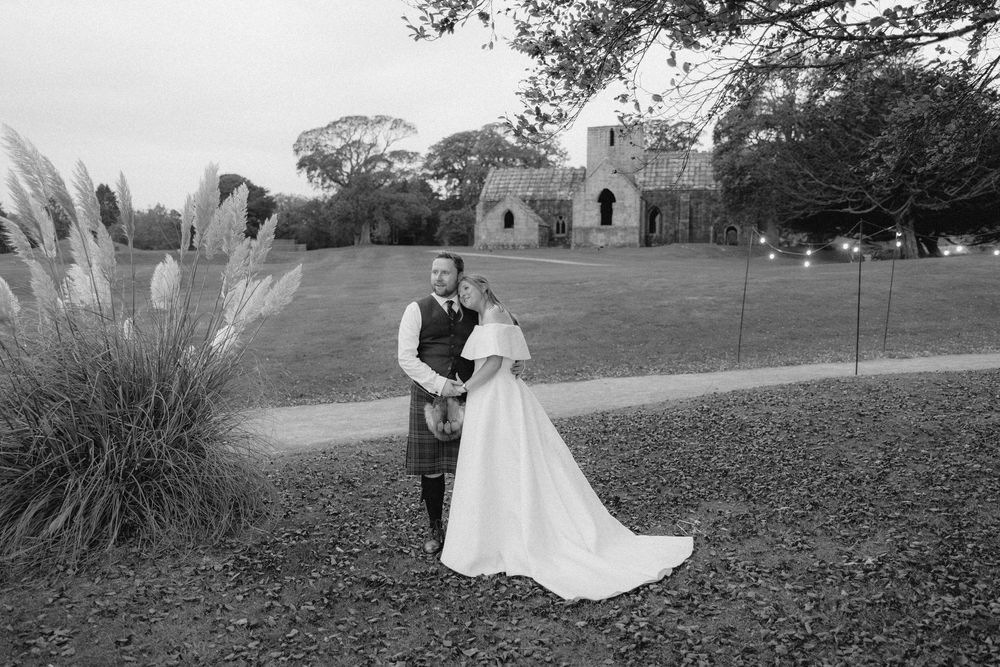 A romantic black and white wedding photo sequence showing a couple dancing in an outdoor garden setting.
