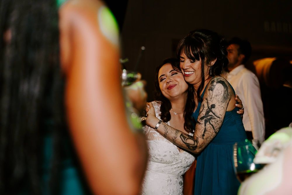 Wedding guests enjoying themselves on a dimly lit dance floor during an evening celebration.