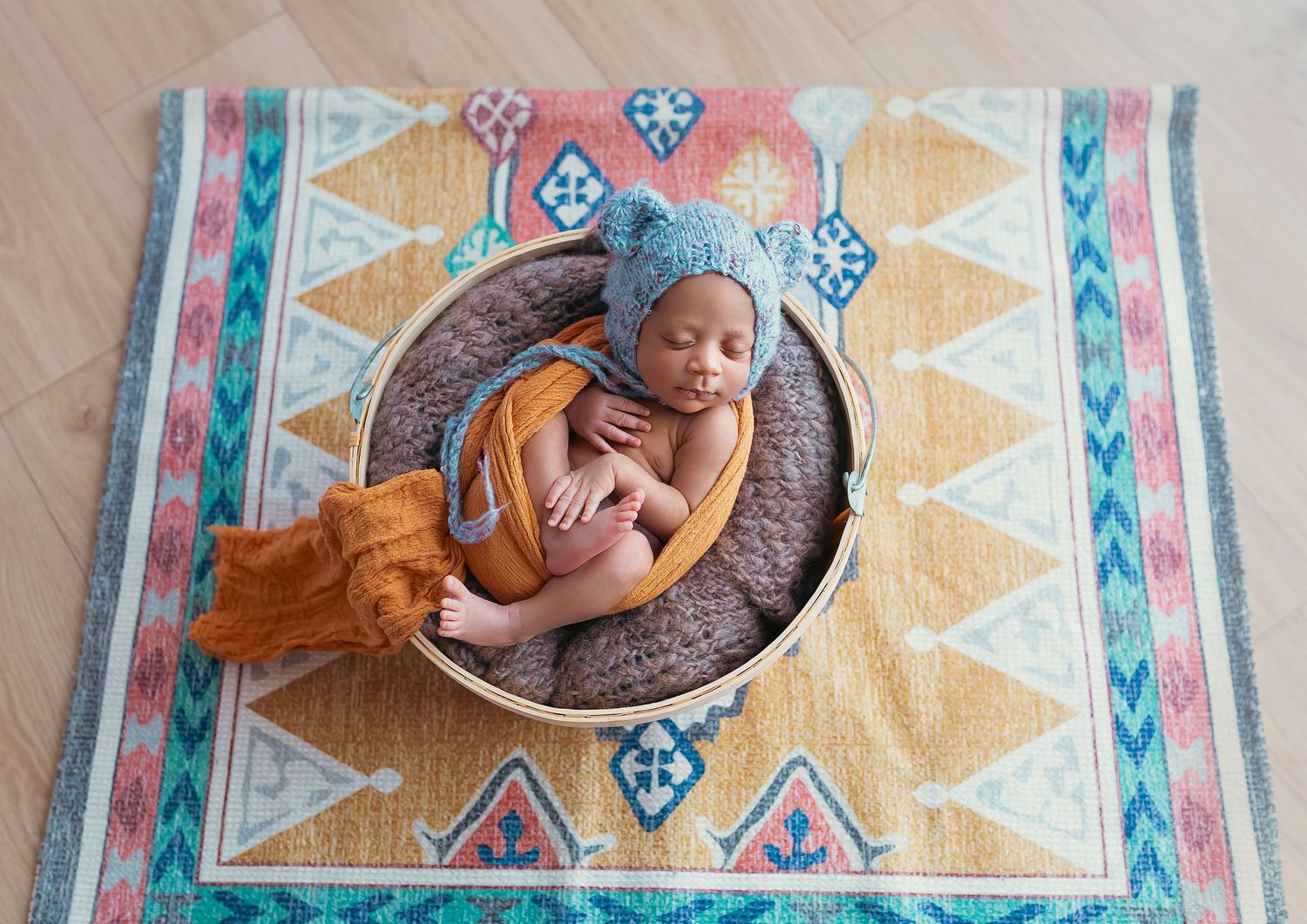 Sesion fotografica de bebe recien nacido dentro de una canasta con un gorrito de osito detres photography