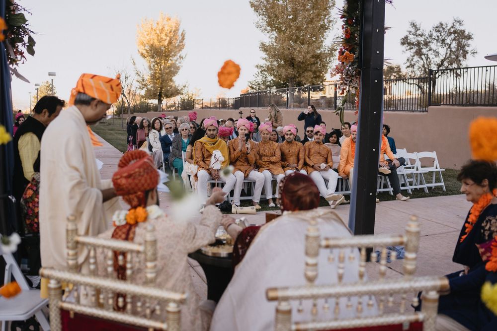 Traditional Hindu wedding ceremony with guests seated outdoors under decorated pergola at sunset.at Sandia Resort and Casino