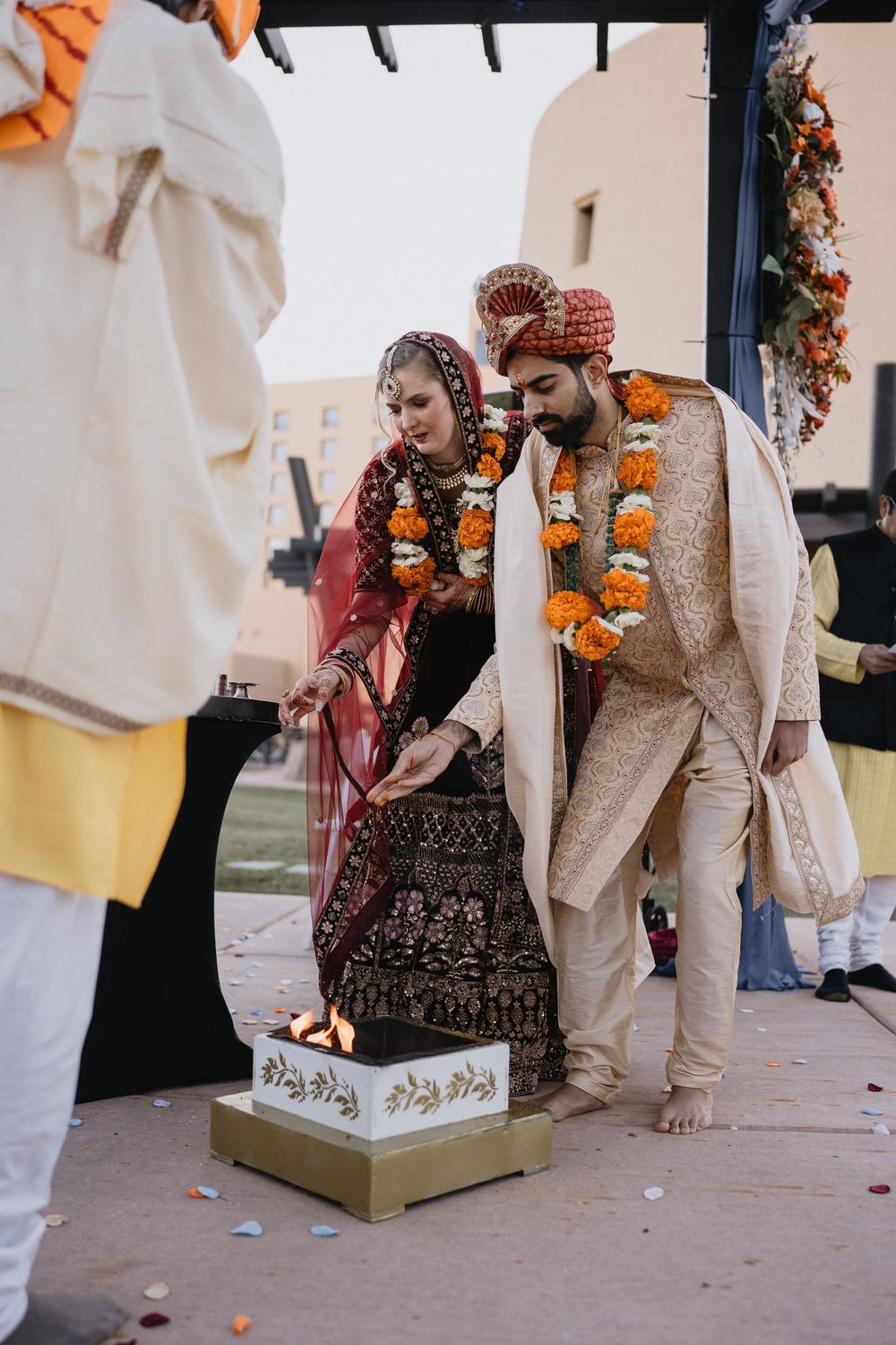 Indian bride and groom performing sacred fire ritual during traditional Hindu wedding ceremony outdoors.at Sandia Resort and Casino