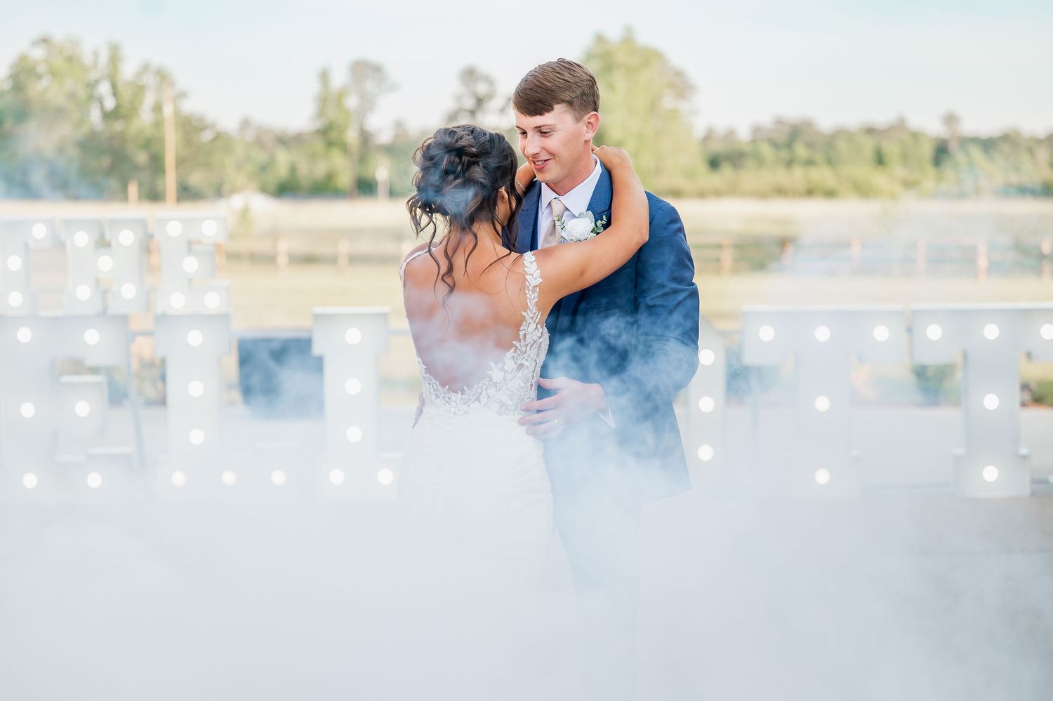 A dreamy wedding photoshoot with soft lighting and sparkles in an outdoor marina setting.
