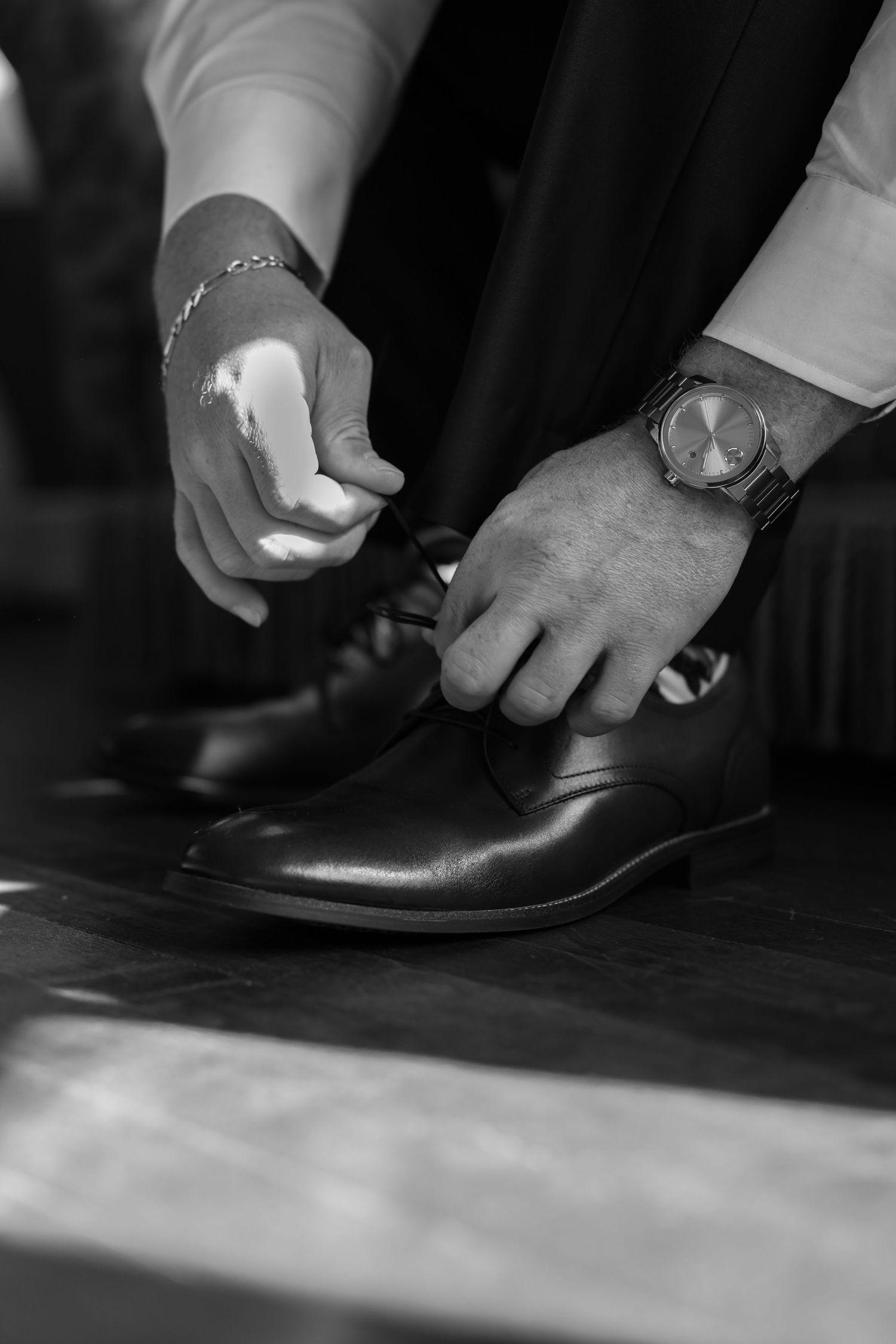 Close-up sequence of hands adjusting formal black leather dress shoes.