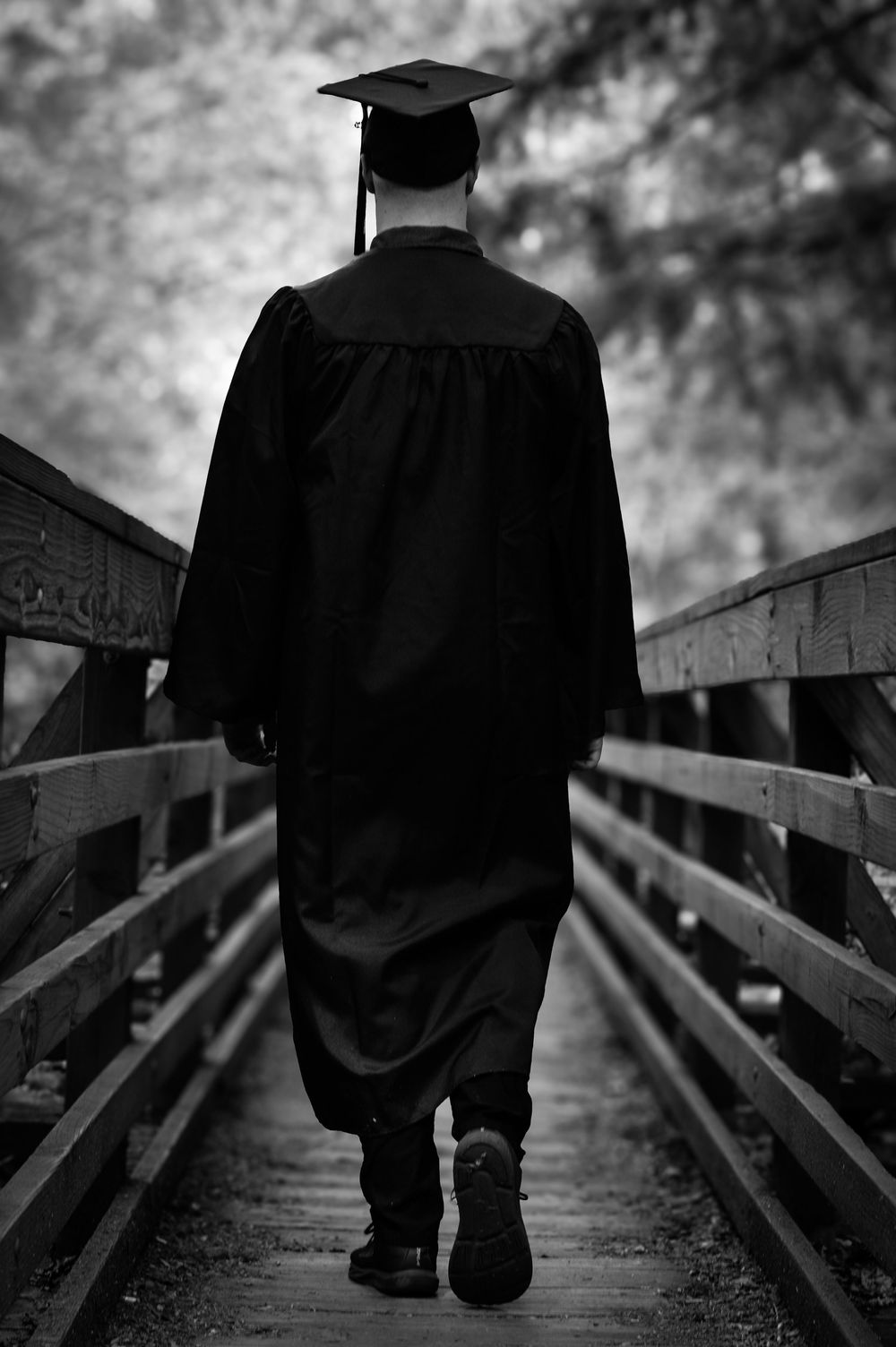 High school graduate walking across bridge