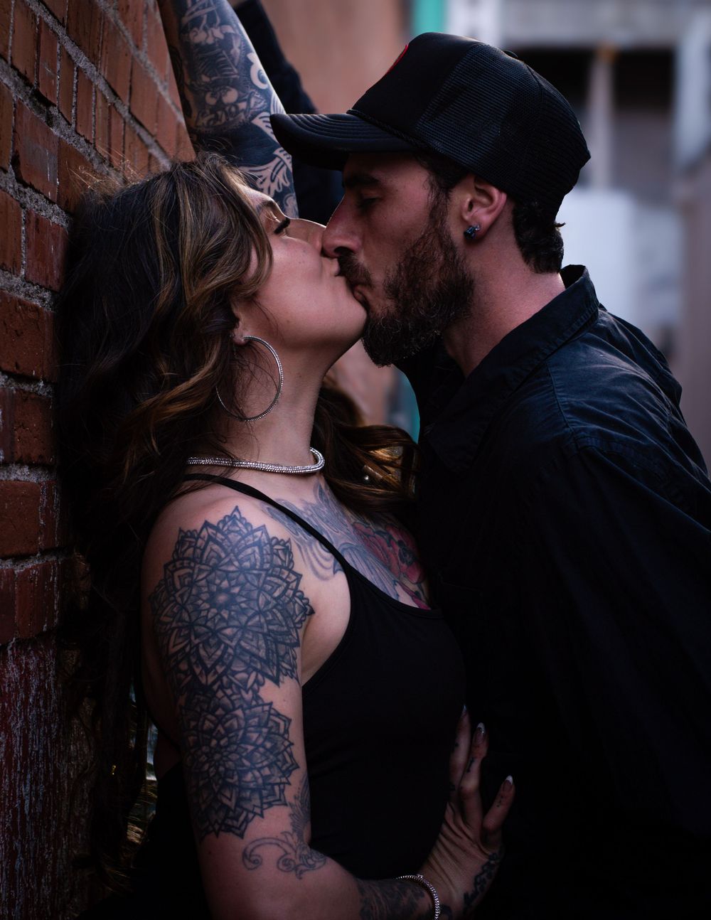 Couple kissing in an alley.