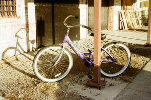vintage bicycle parked in a line against a brick wall in sepia-toned lighting.