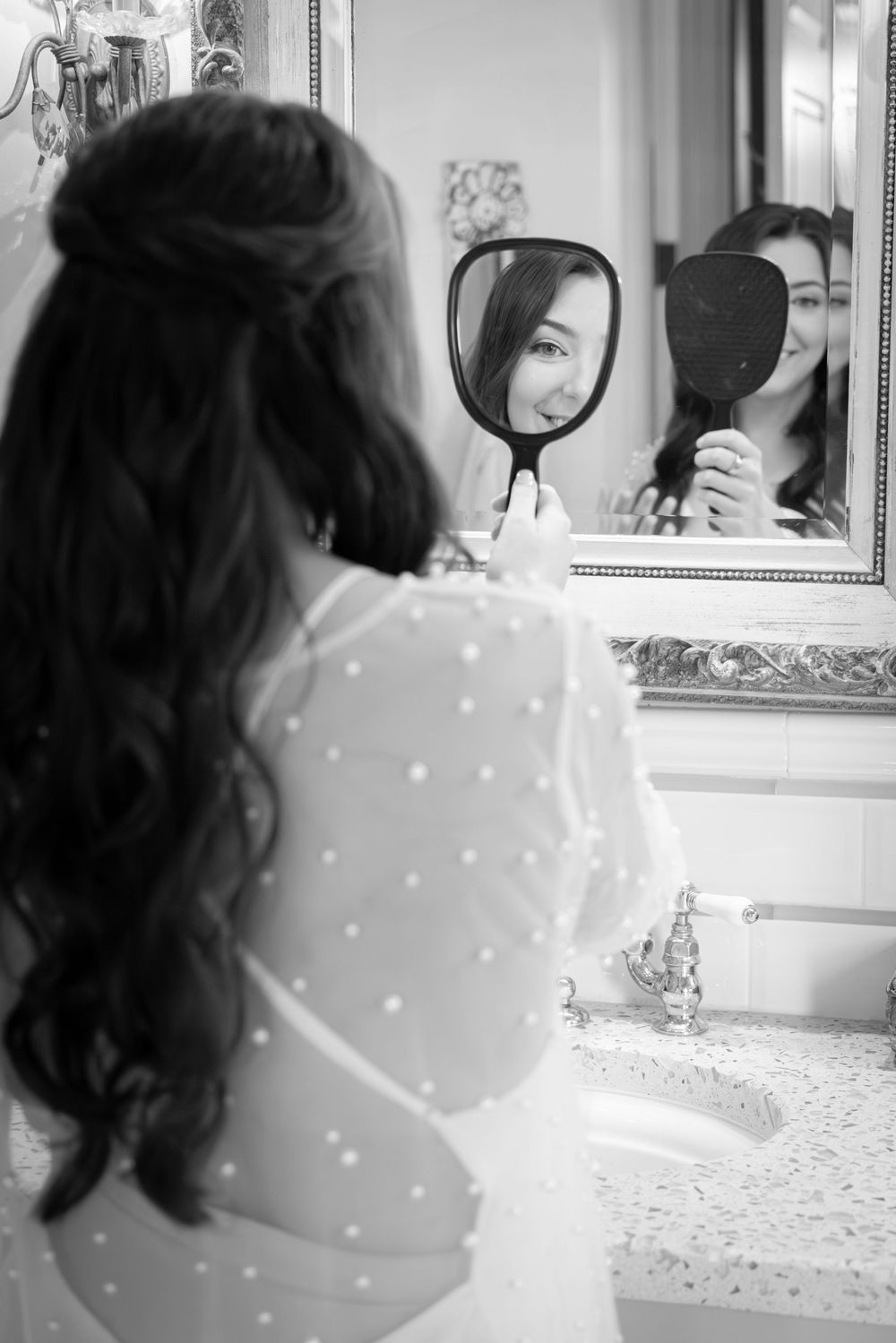 Black and white photo showing wedding preparation details with mirror reflections and polka dot patterns.