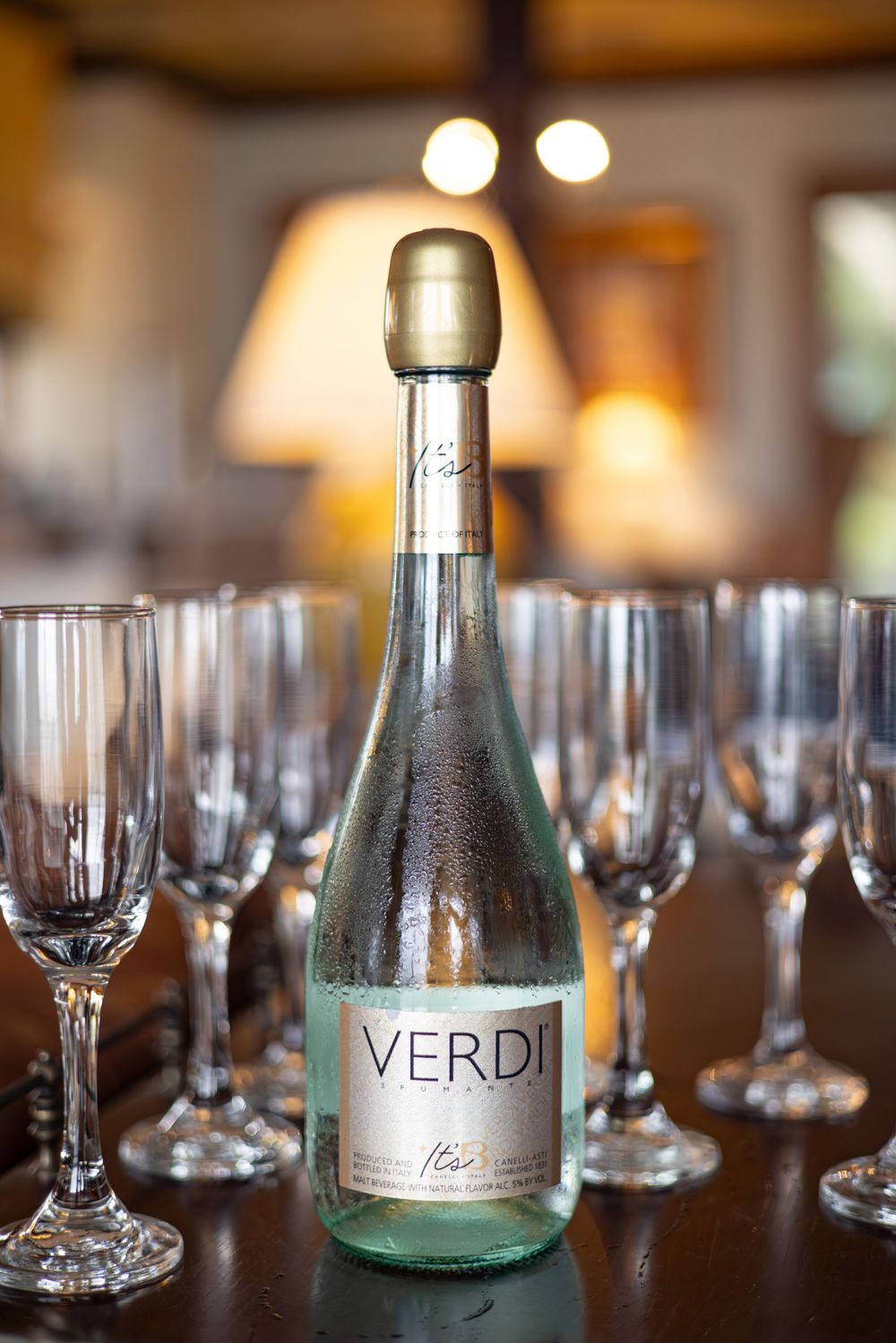 Table set with wine glasses and Verdi bottles for elegant dinner service.