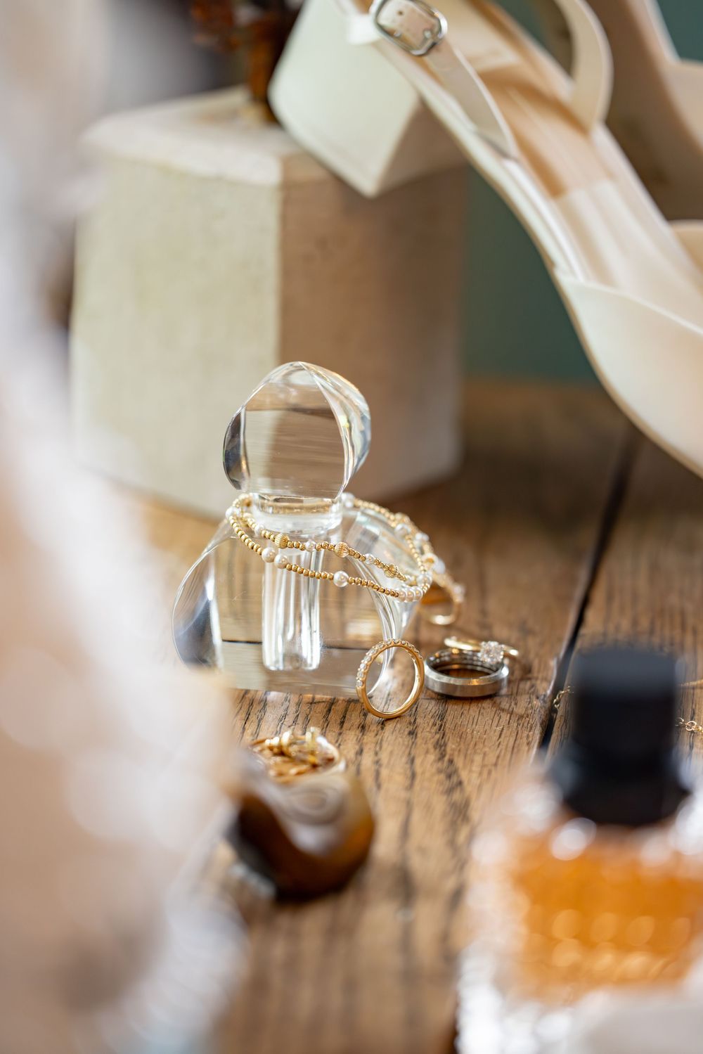 Wedding rings and small decor items artistically arranged on rustic wood surface.
