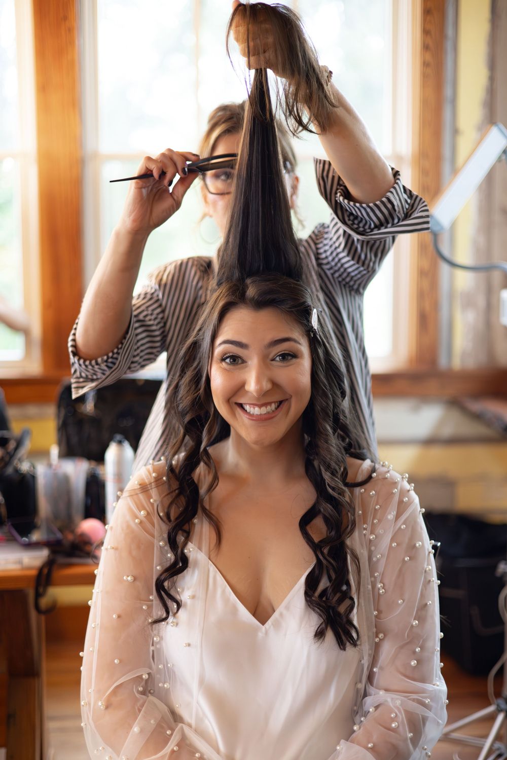 Getting ready scene with hairstyling preparations in a sunlit room.