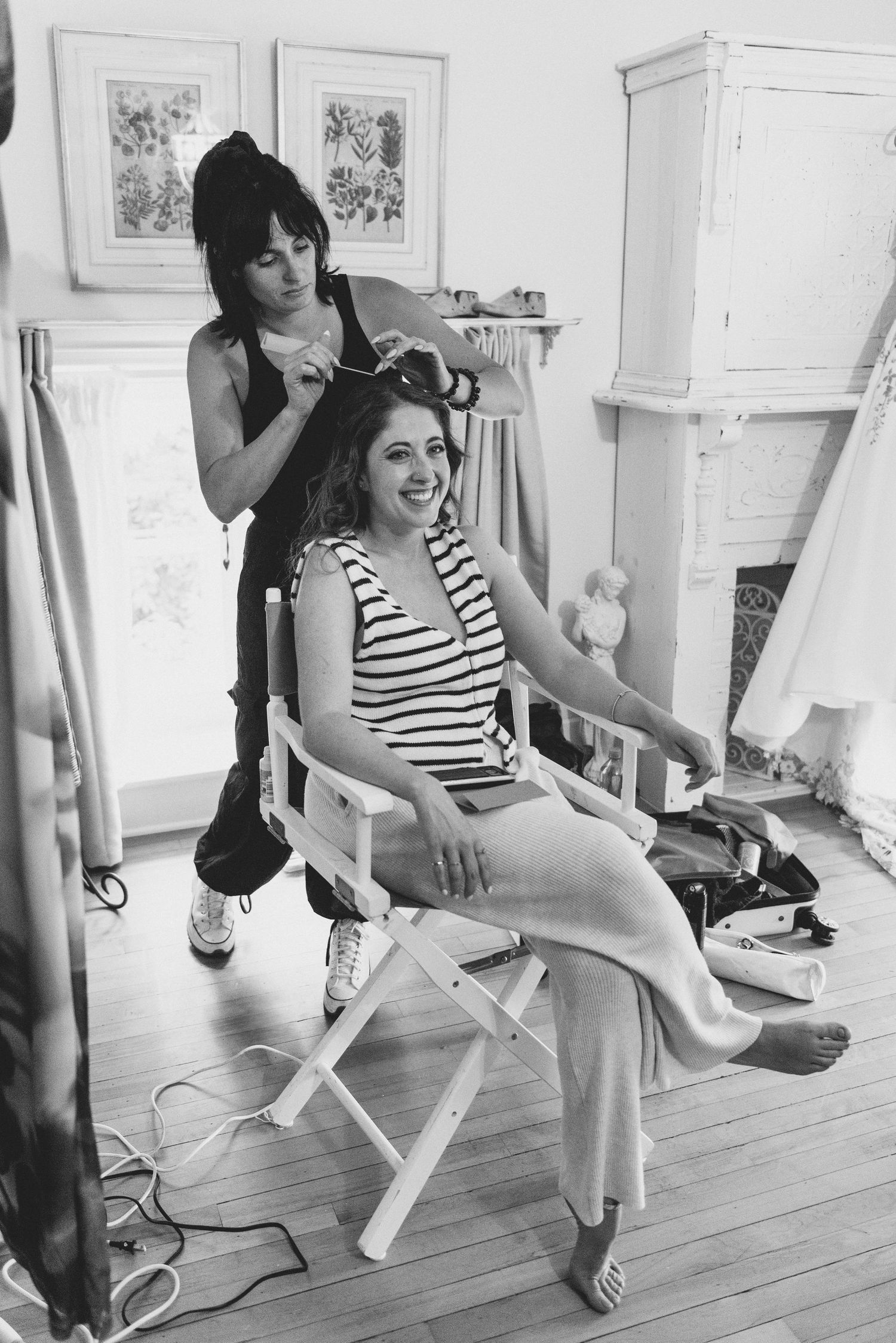Behind-the-scenes preparation showing styling and makeup session in a bright room with white decor.