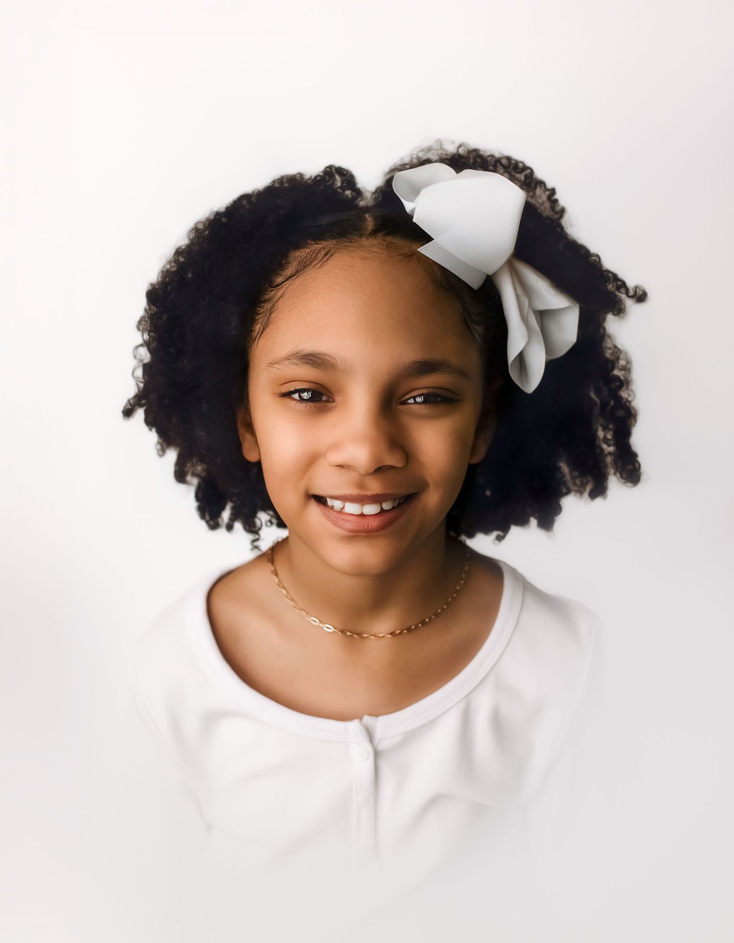Heirloom vignette image of nine year-old girl wearing a white bow and shirt, captured by Charlottesville baby and family photographer.
