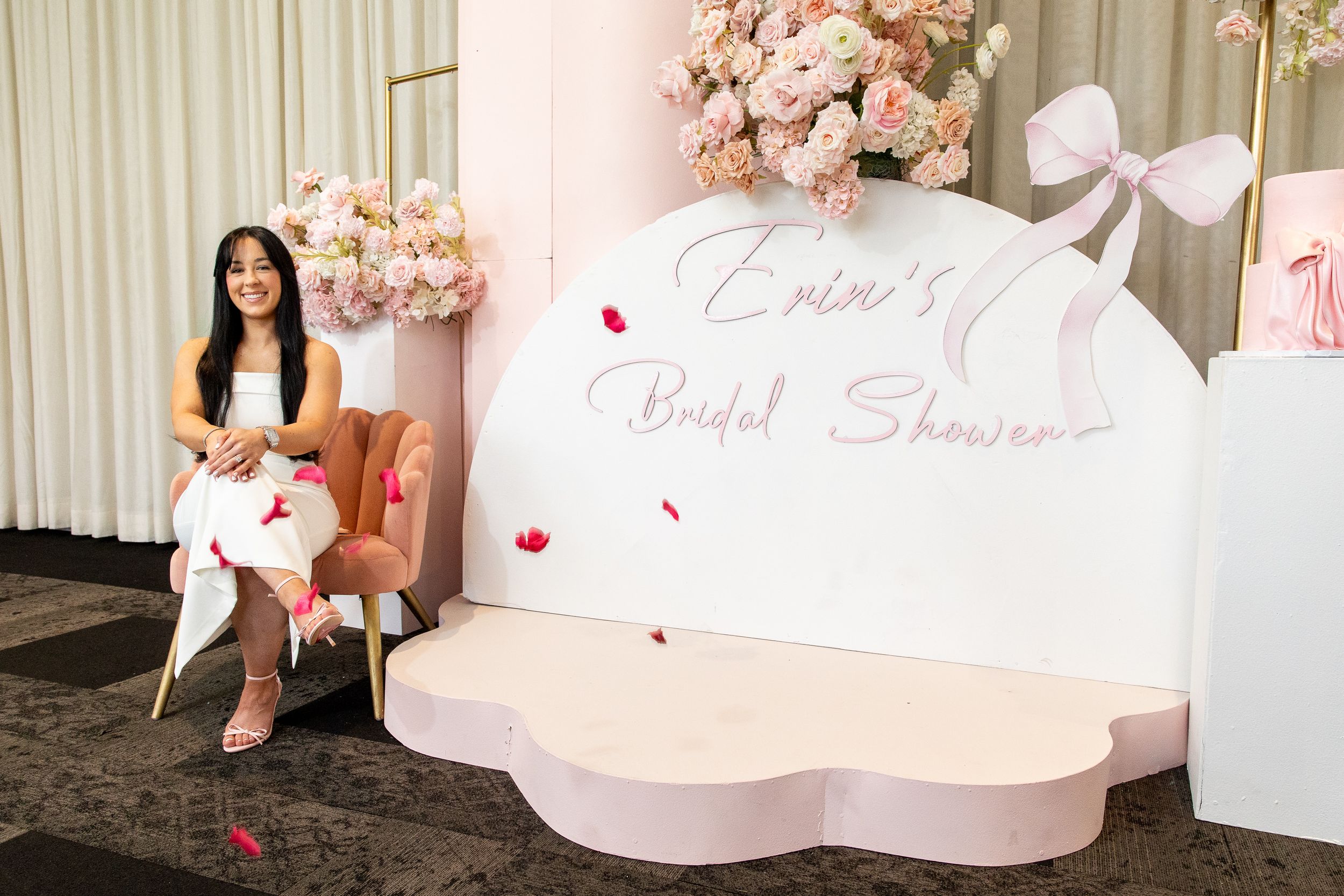 Pink floral decorated bridal shower setup with elegant signage and decorative elements.