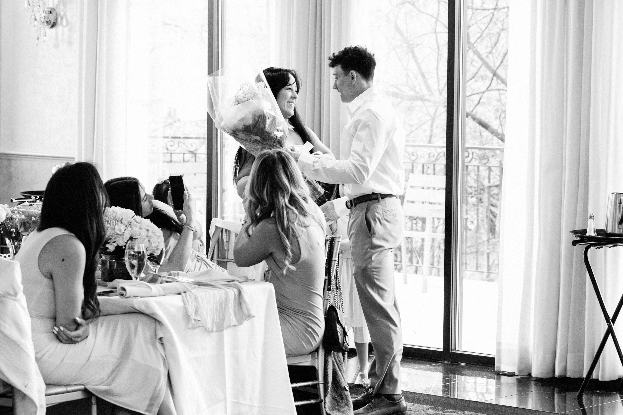 Bright sunlit room with large windows where celebration activities are taking place.