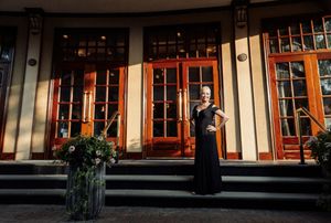 Panoramic view of an industrial warehouse exterior with large glass windows and orange accents at sunset for 70th birthday party at VIP.