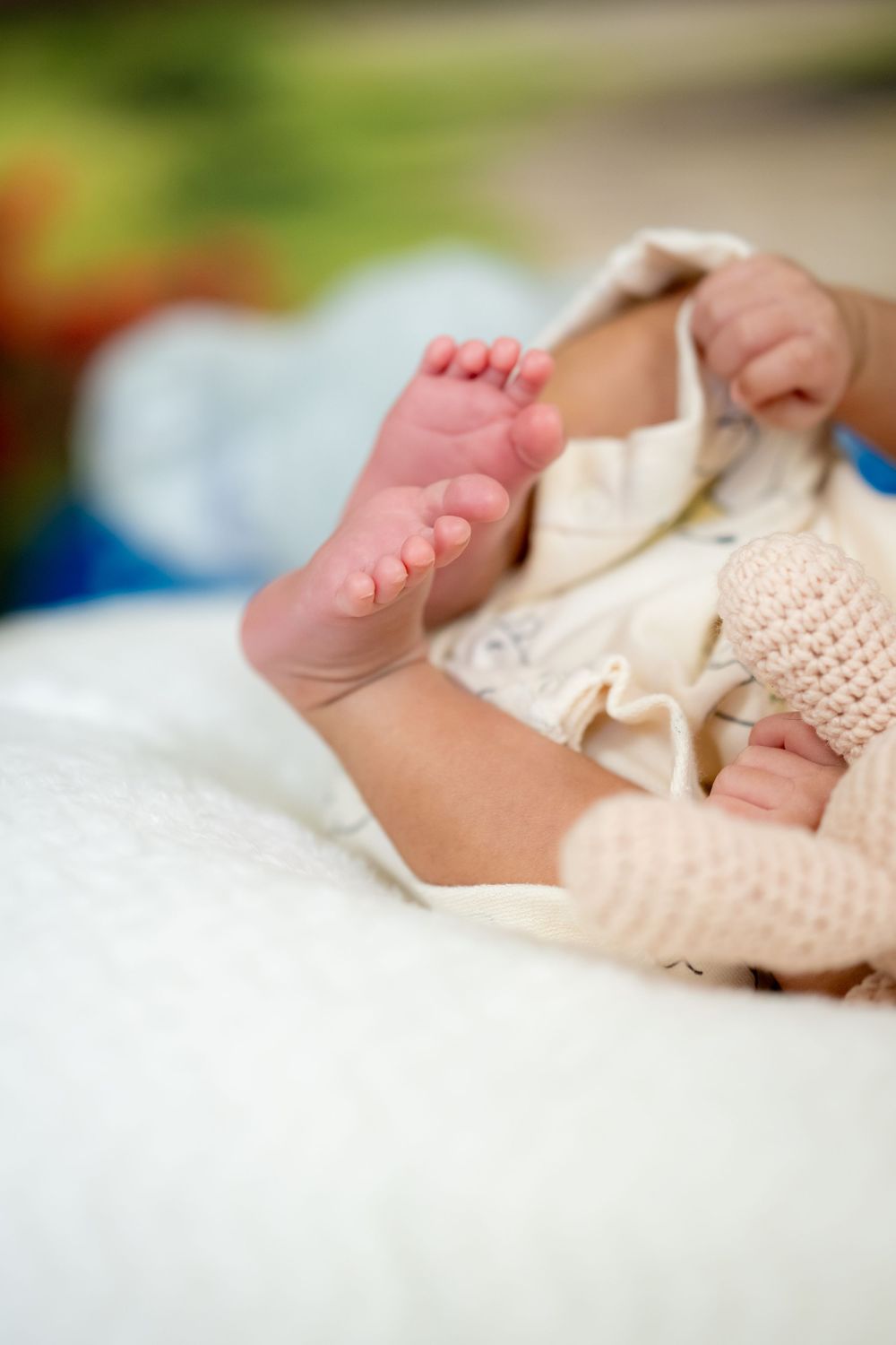 A series of closeup shots showing tiny newborn baby feet wrapped in soft knitted blankets and fabrics.