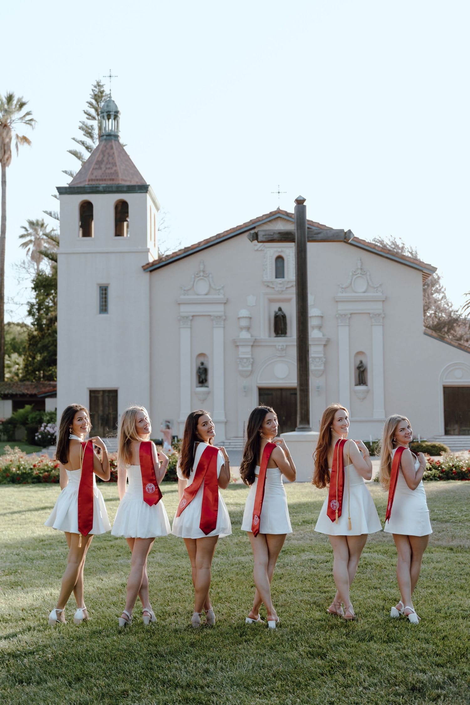 Group of college graduates pose in front of Mission Santa Clara de Asís Santa Clara University. Taken by Bay Area Grad Photographer.