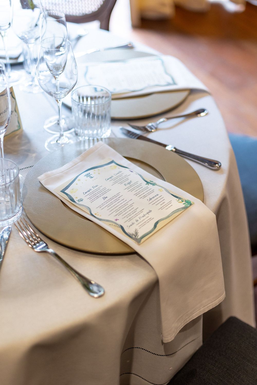 Formal place settings with menus and silverware on white tablecloths.