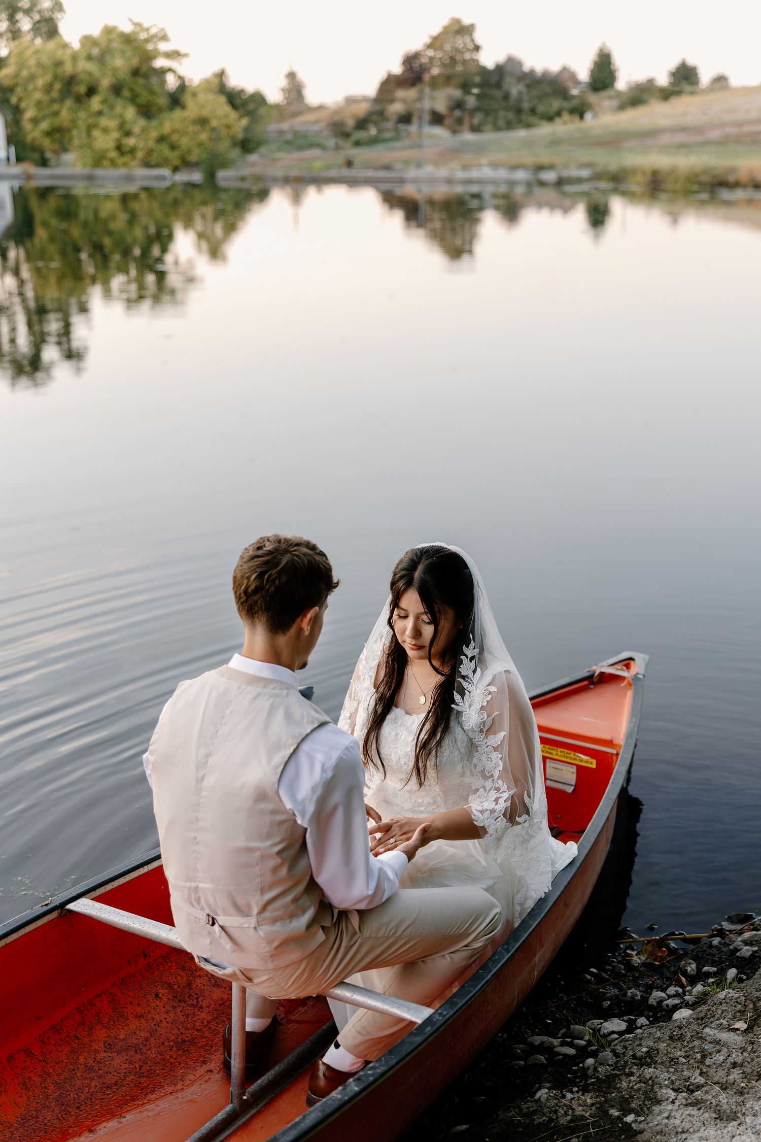 Sunset bride and groom portraits in a canoe on a pond