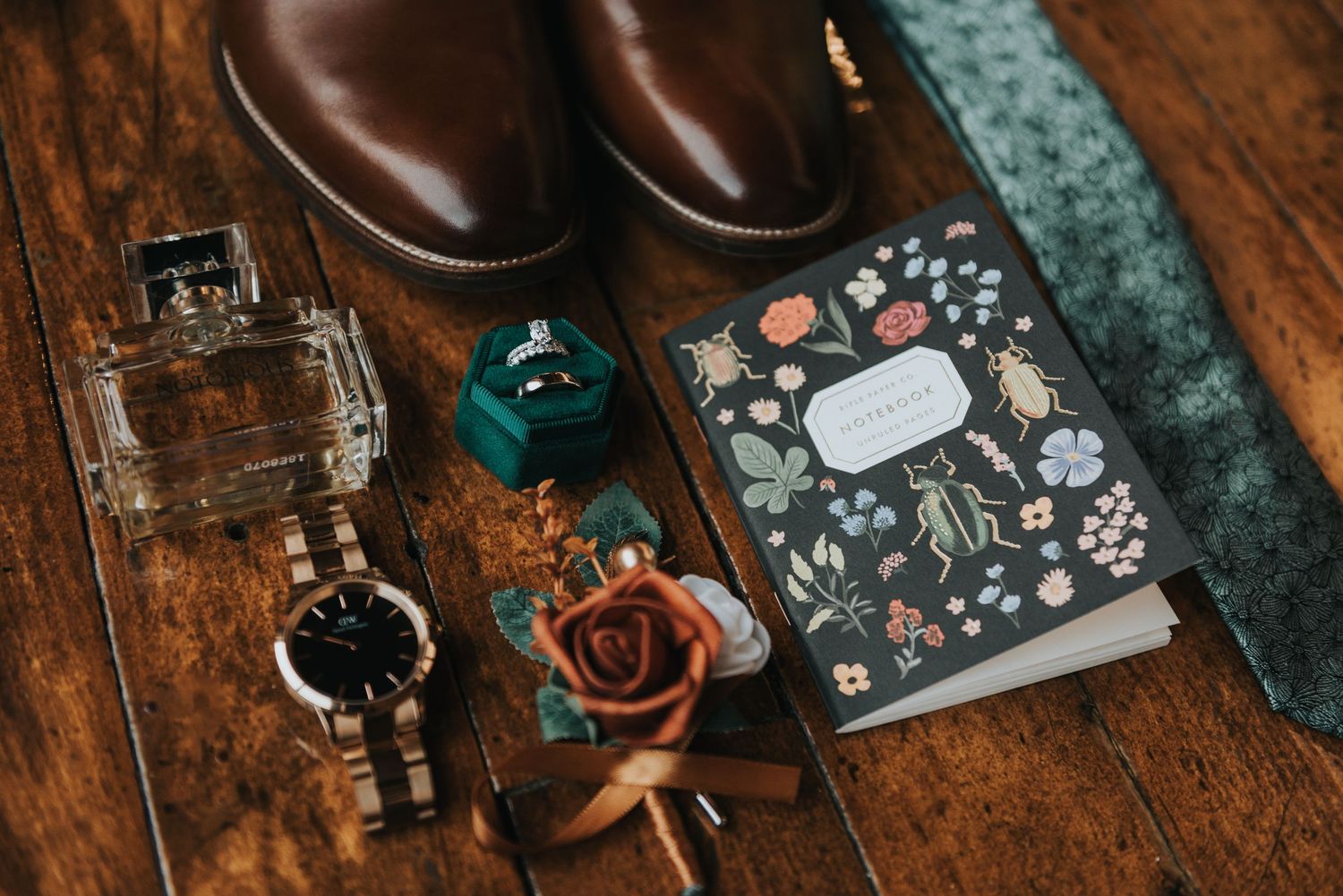 Brown leather boots and small electronic gadgets arranged on a rustic wooden surface.