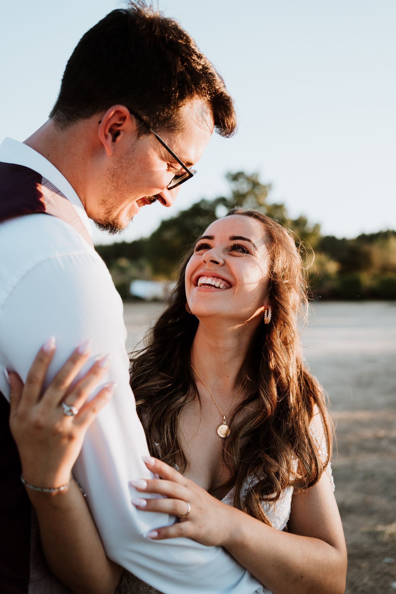Romantic sunset moment captured between couple in formal wedding attire.
