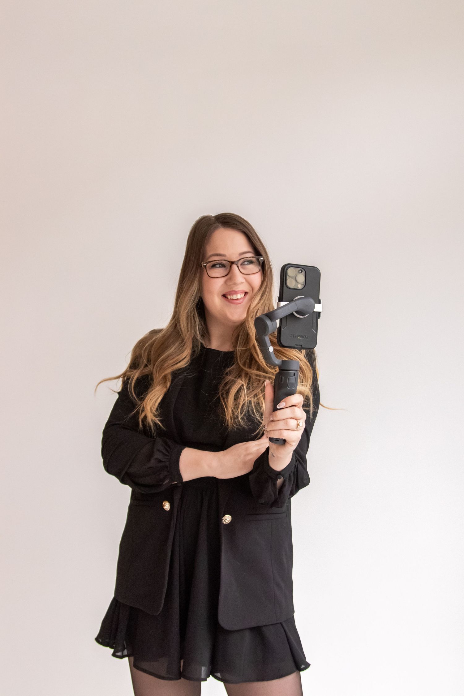 Portrait of photographer holding vintage camera against white background.