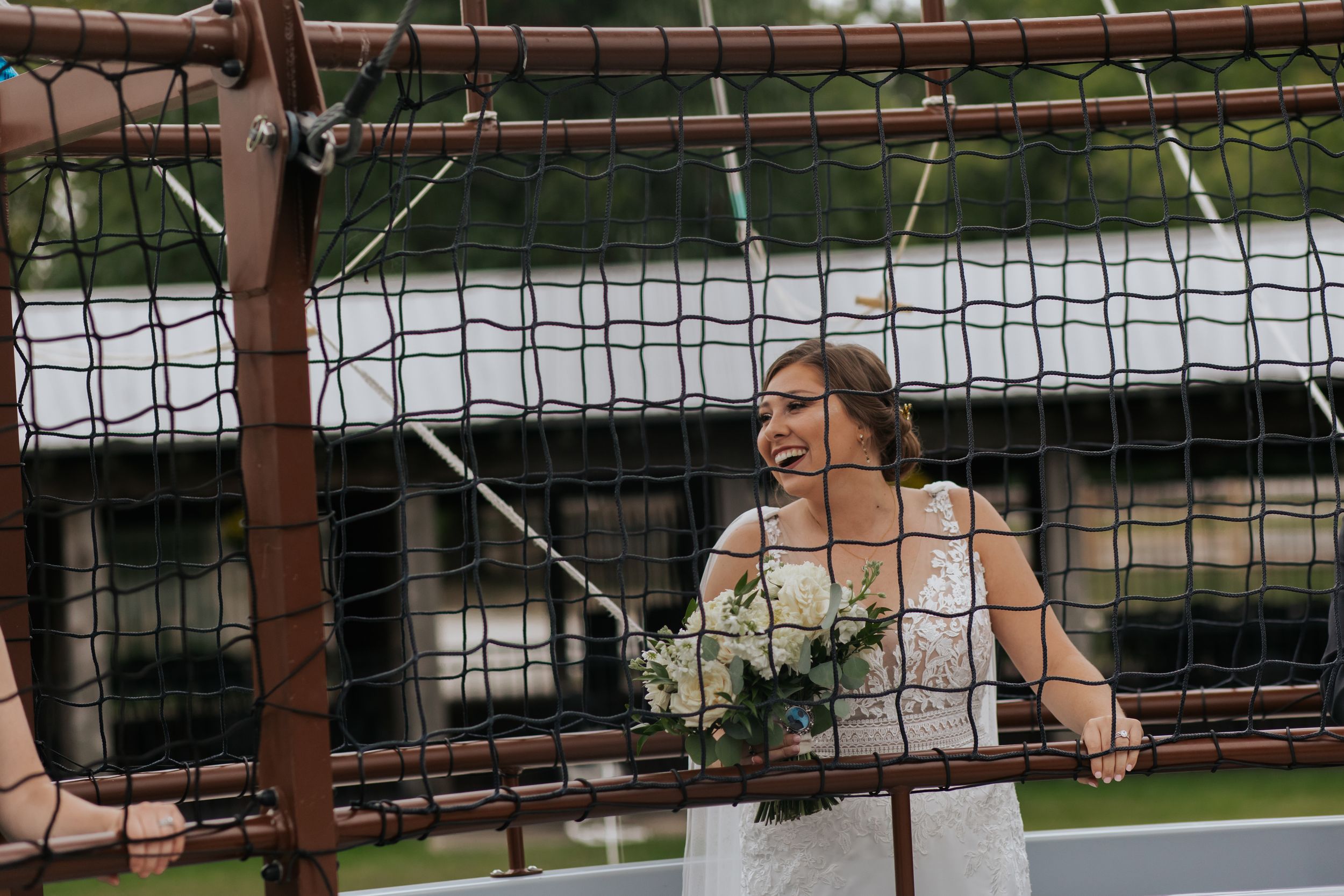 A wedding moment captured through netting in an outdoor setting.