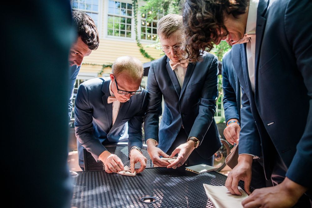Wedding guests sign a guestbook or document at reception table.