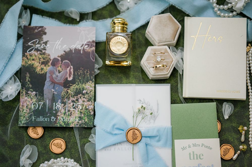 Wedding detail shots showing invitation suite, rings, and decorative elements in soft neutral tones.