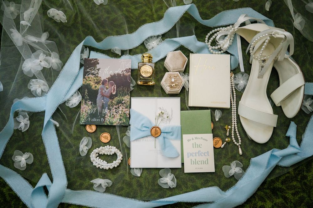Wedding accessories and decorative elements arranged with light blue ribbons on dark background.
