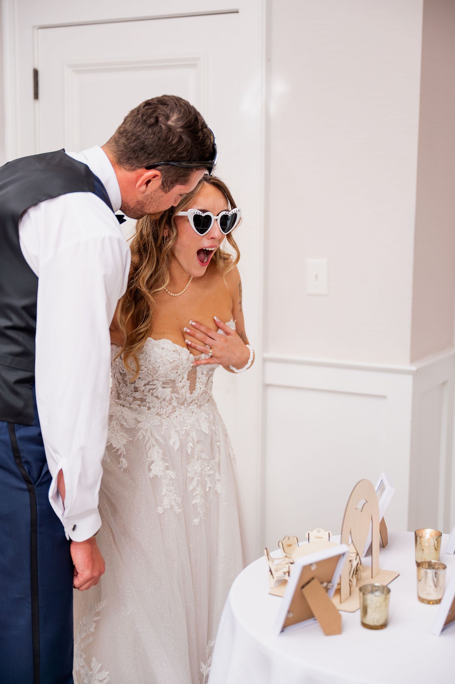 Couple sharing a playful moment at their wedding reception with sunglasses and formal attire.
