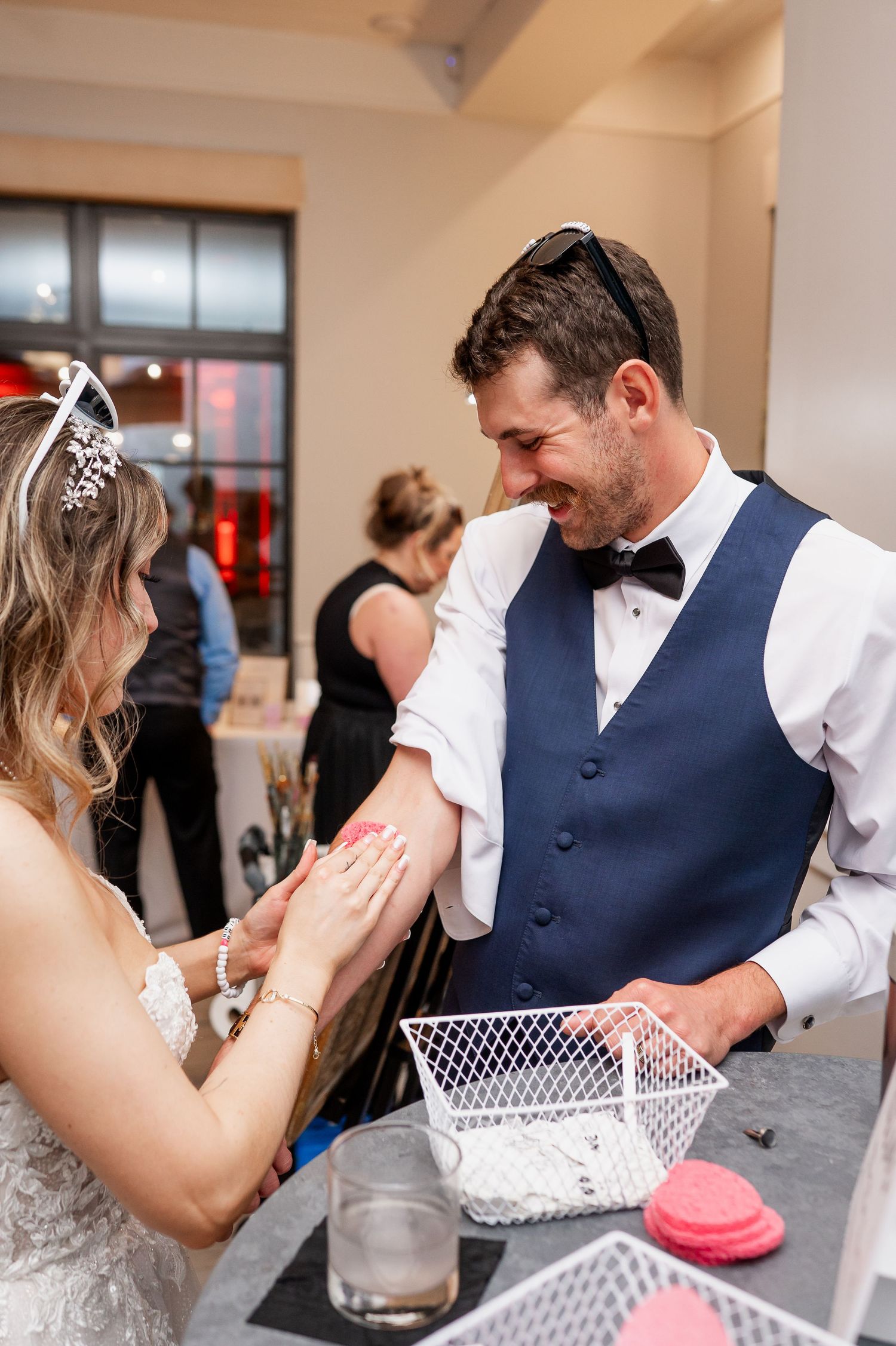 Wedding couple playing a reception game with white baskets at their celebration.